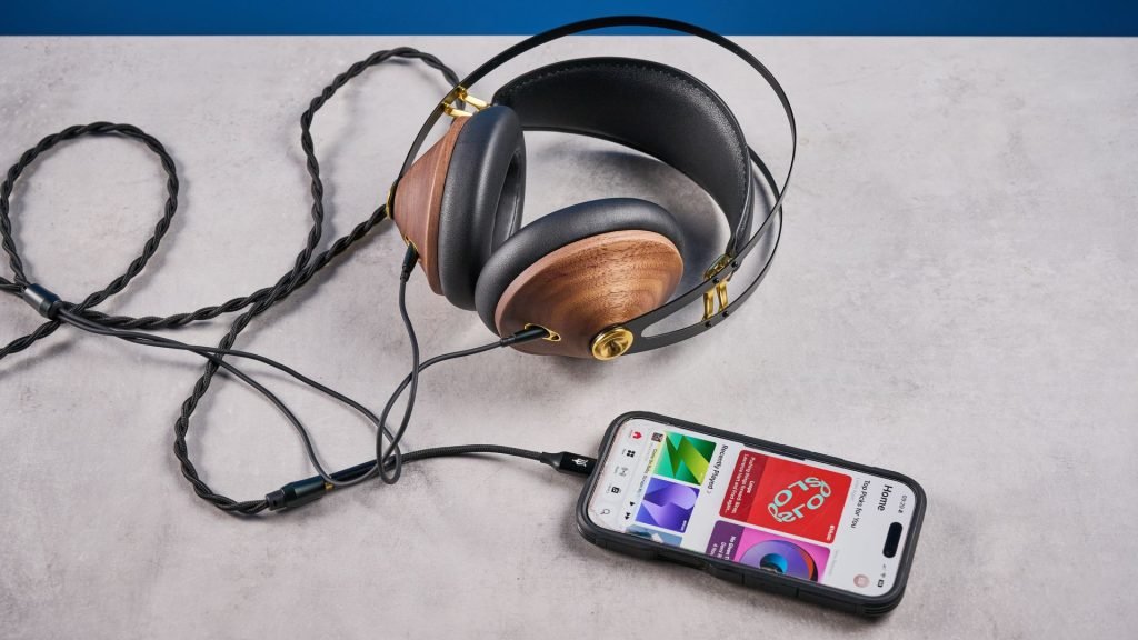 the meze 99 classics 2nd gen headphones with walnut finishes and gold touches against the blue tom's guide background