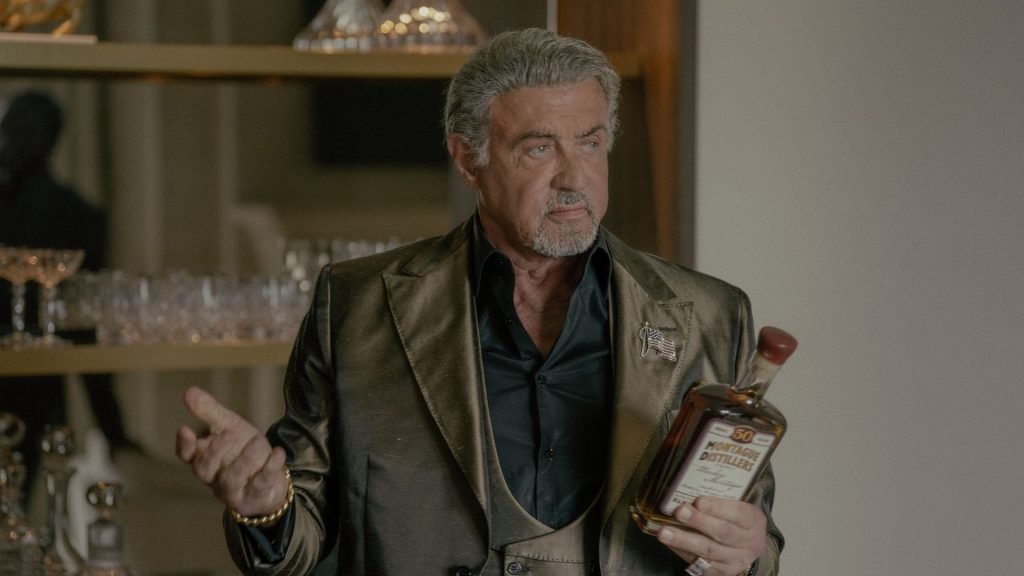 Dwight holds some alcohol in front of a bar in Tulsa King season 3