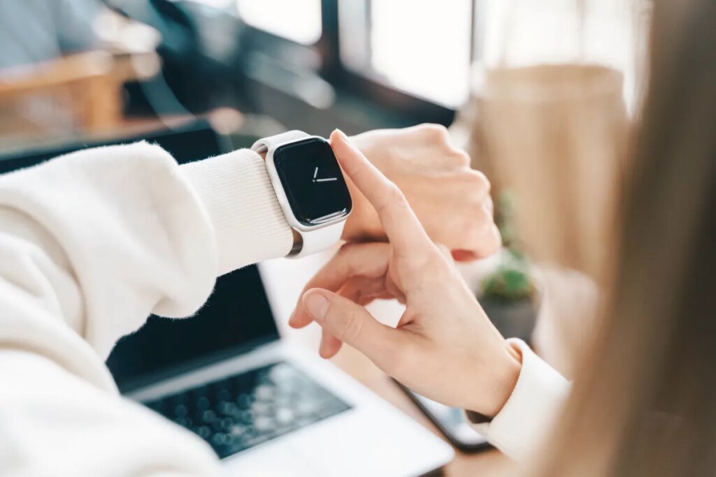 Best Apple Watch apps for boosting your productivity Modern woman using smart watch for daily tasks, interacting with the touchscreen user interface. Tracking health habits, messaging, checking on time with simple application software.