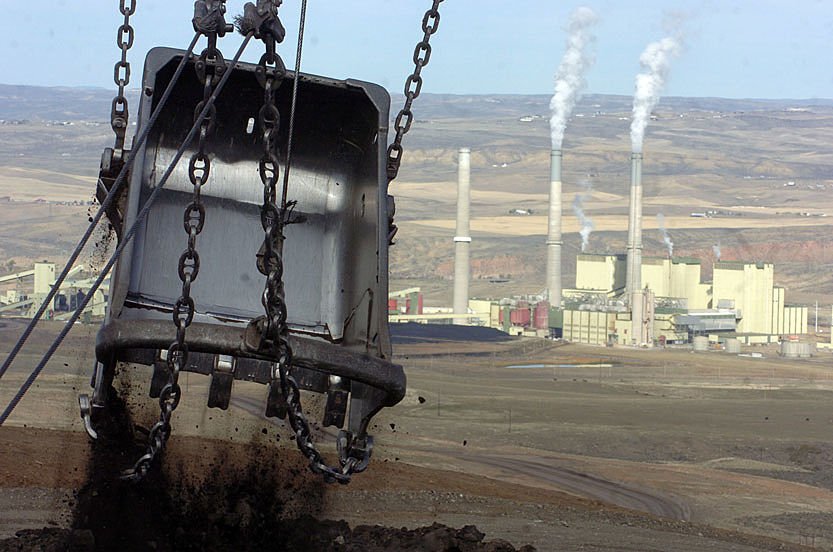 Here we go again: Retiring coal plant forced to stay open by Trump Admin Image of a large metallic shovel suspended from chains in the foreground, with a coal generating plant in the background.