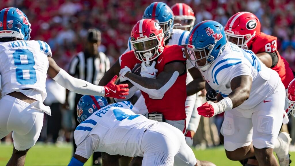 Will Echoles of the Mississippi Rebels tries to wrap up Nate Frazier of the Georgia Bulldogs during a college football game.