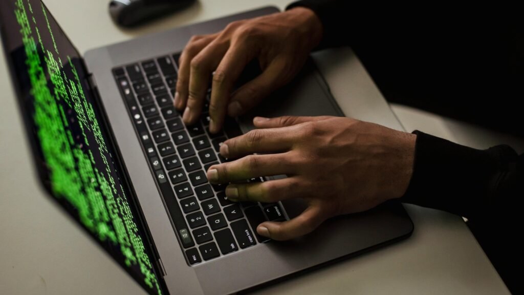 Deepfakes, AI phishing, and Dark LLMs are changing the cybercrime game in ways that scare even experts A hacker typing on a MacBook laptop with code on the screen.
