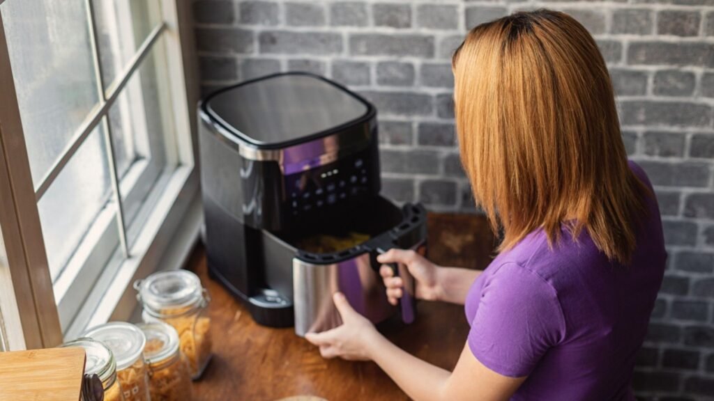 How to give your air fryer a deep clean, and keep it looking – and cooking – like new Woman opening air fryer drawer
