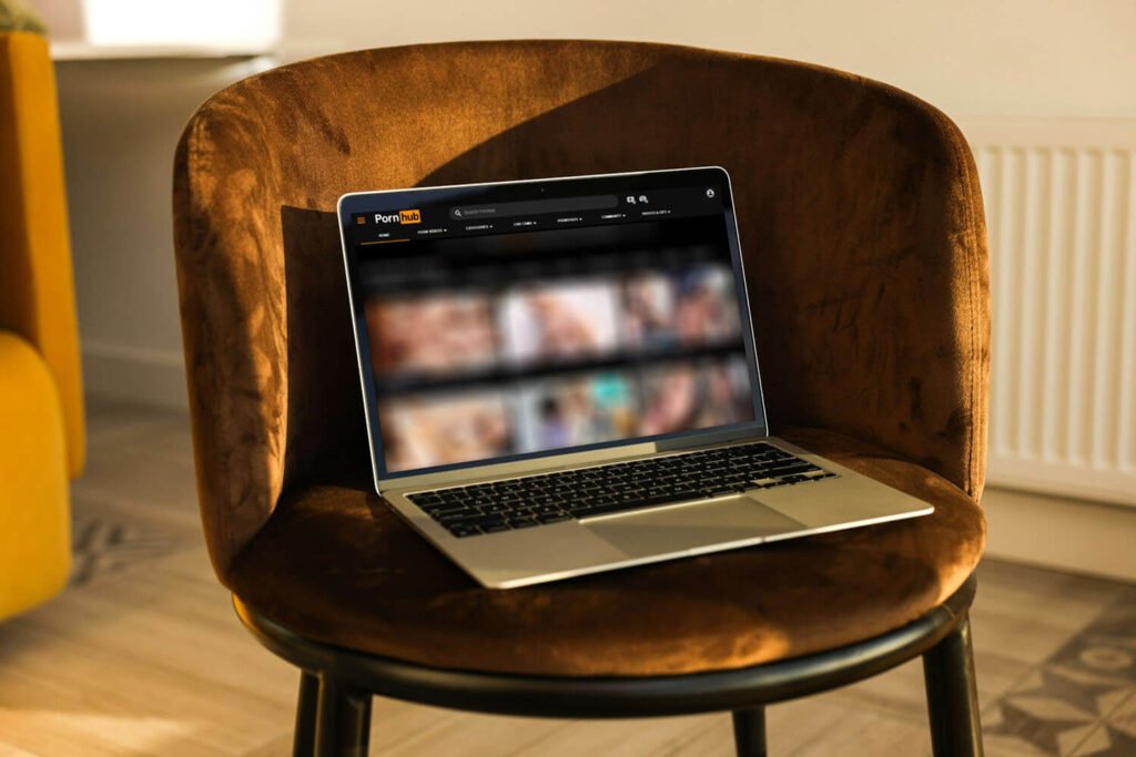 A laptop on a bench with the screen blurred to obscure pornographic images.