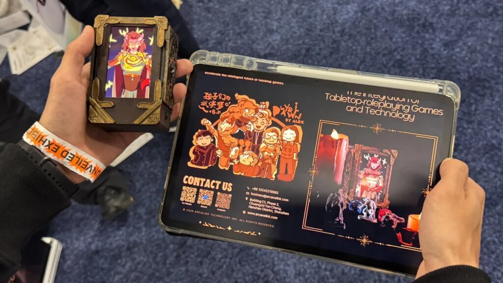 Transport Your Dungeons & Dragons Hero Off the Page With This Tabletop Gadget Two hands holding products: the left holds a digital screen displaying a fantasy character, while the right holds a tablet displaying game management software.