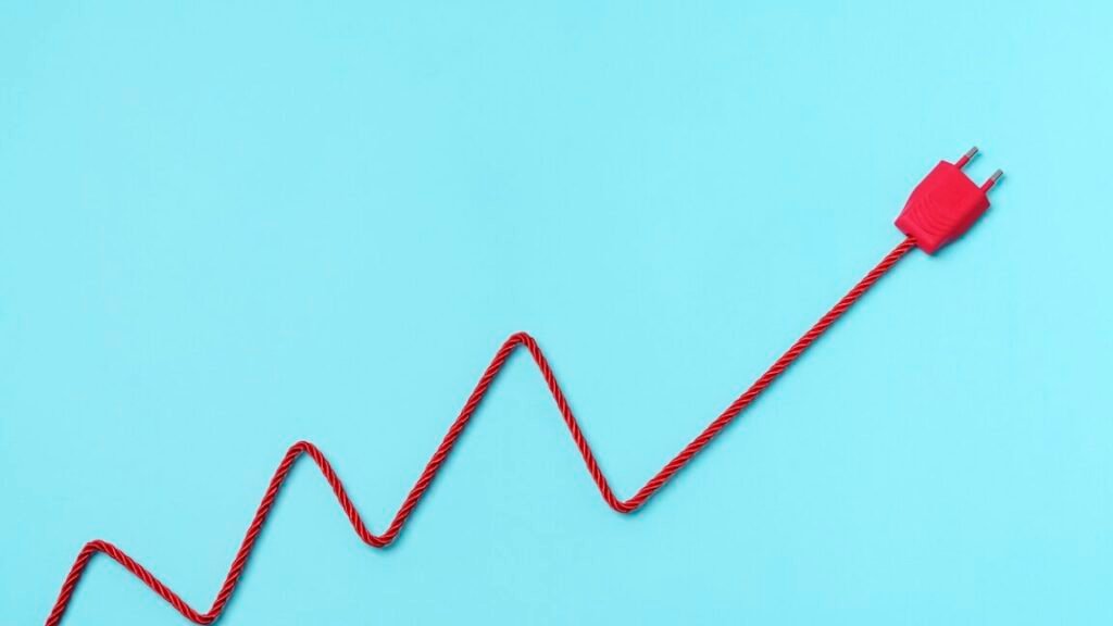 Red Electric Power Plug Adn cable forming a chart on blue background. Increase to electricity prices concept.