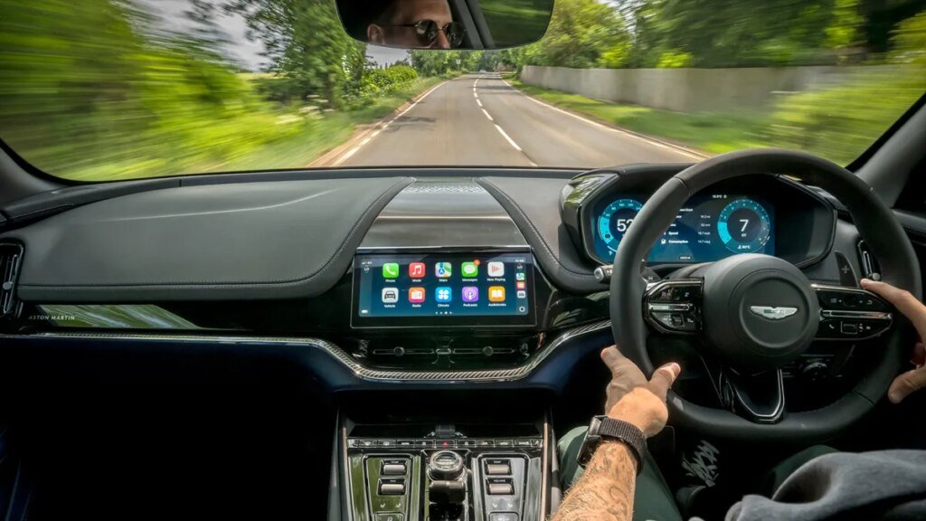 Apple May Be Adding Support for Conversational AI in CarPlay Someone driving an Aston Martin using CarPlay Ultra
