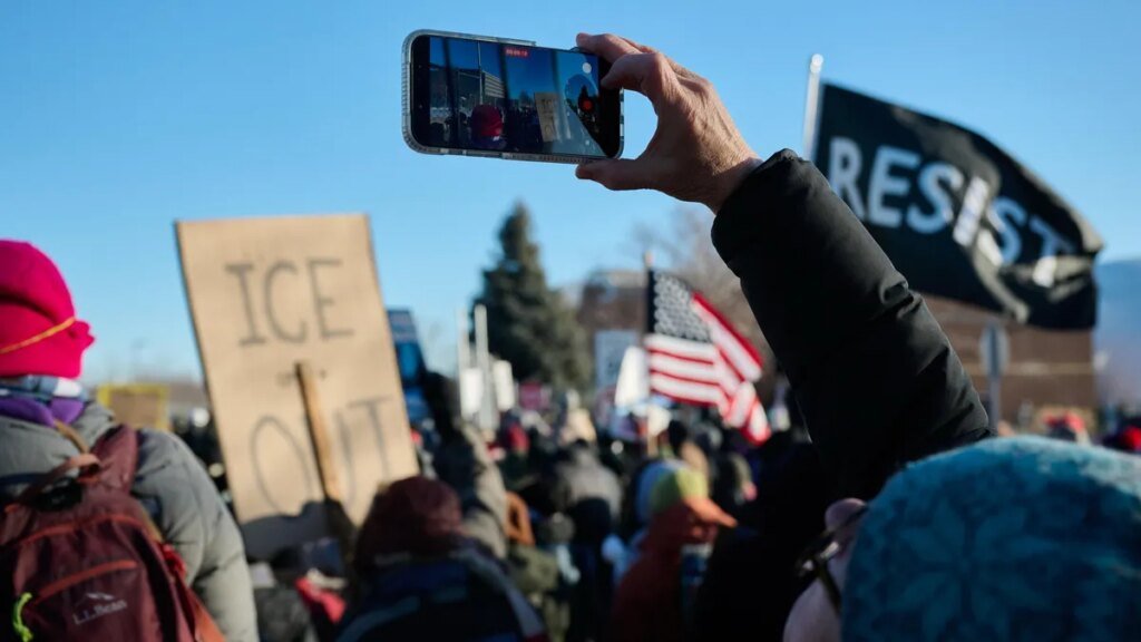 A demonstrator against the ongoing Immigration and Customs Enforcement (ICE) deployment records on a phone during a protest outside the Bishop Henry Whipple Federal Building in St. Paul, Minnesota, US, on Friday, Jan. 30, 2026. Employment records of at least two Minneapolis-area businesses are being audited by the Department of Homeland Security, in what state and local officials describe as retaliation over the fallout from the Trump administration's immigration crackdown in Minnesota.
