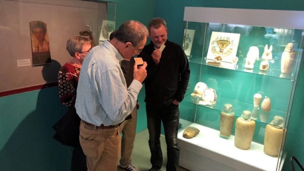 Visitors sniffing the Scent of the Afterlife card during a guided tour at the Museum August Kestner, Hannover, Germany