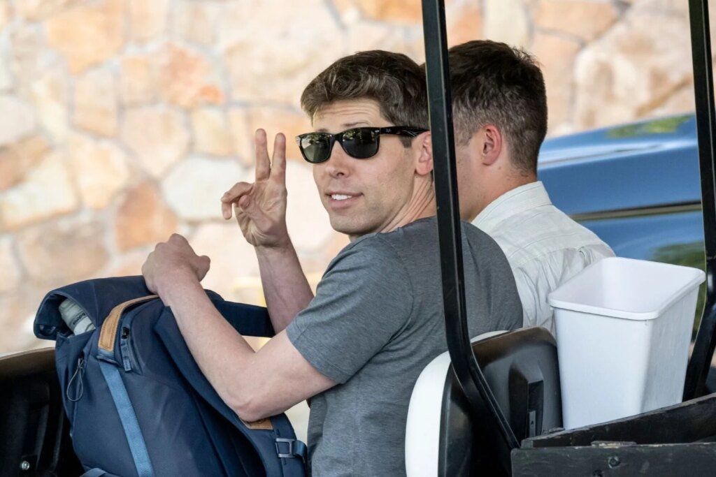 OpenAI CEO Sam Altman wearing sunglasses and holding up the peace sign while driving a golf cart