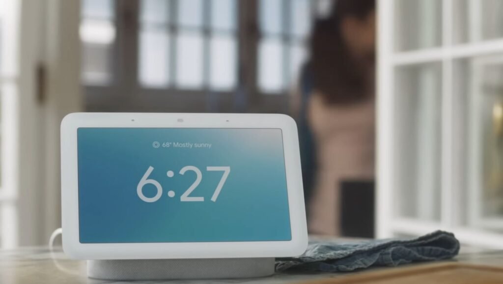 A Google Nest Hub showing its digital clock and clear weather.
