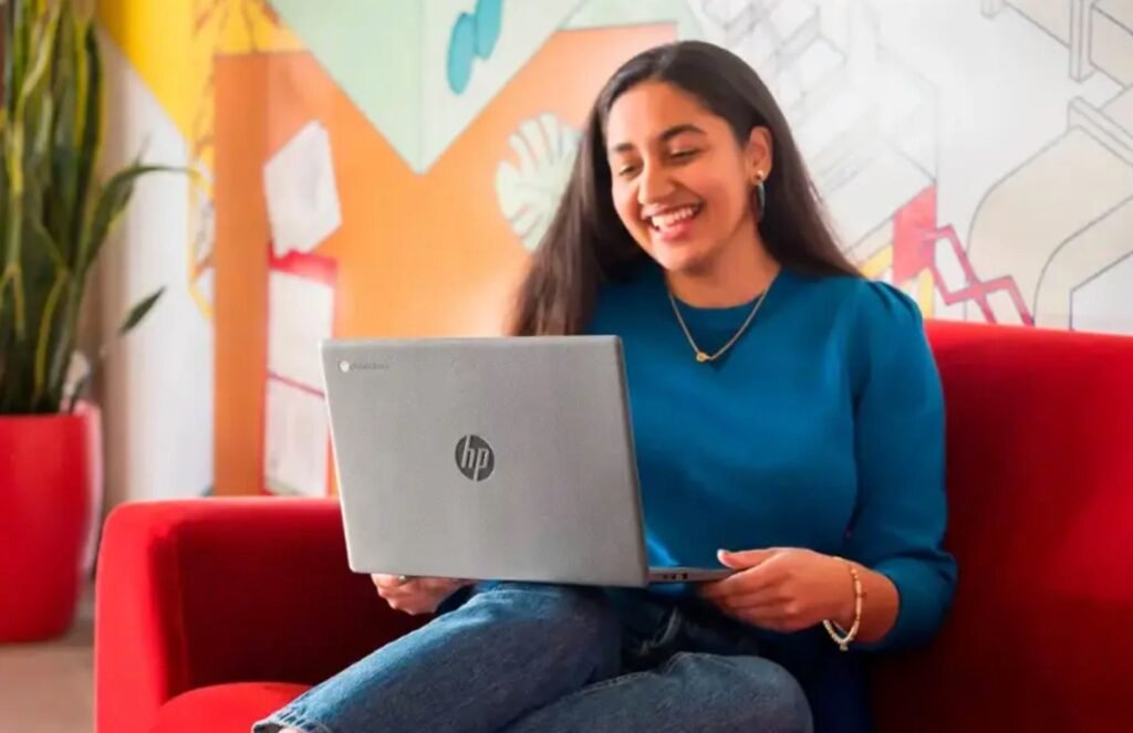 A person smiling with an HP laptop on their lap